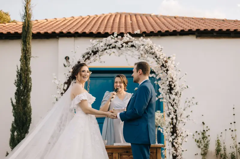 cerimônia de casamento ao ar livre com noivos sorrindo para foto do Gustavo Quagliato