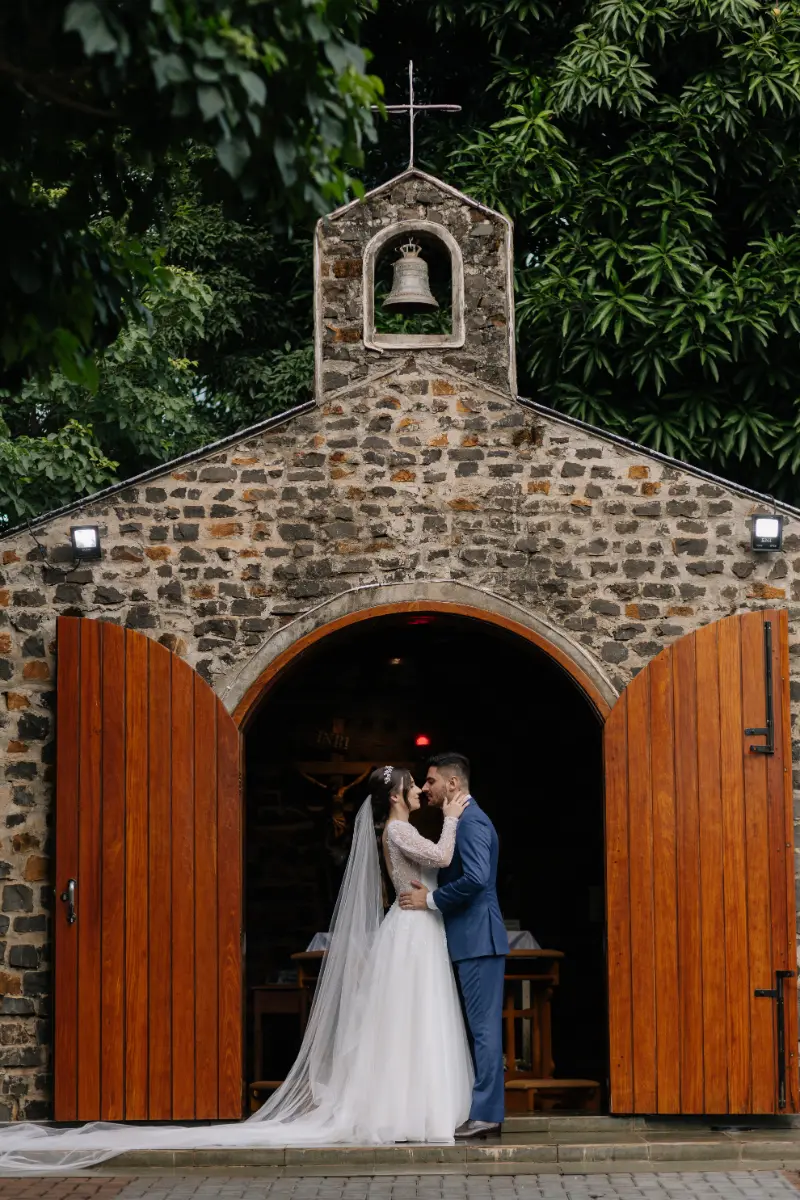 noivos se abraçando em capela rústica de tijolos