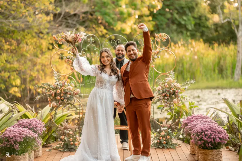 noivos comemorando em frente ao lago no espaço de cerimônia