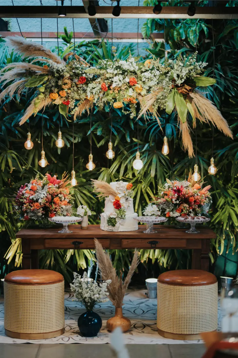 arranjos suspensos de folhagem seca em mesa do bolo