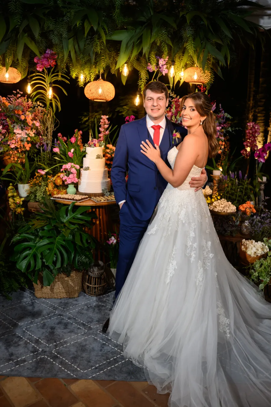 noivos na frente da mesa do bolo