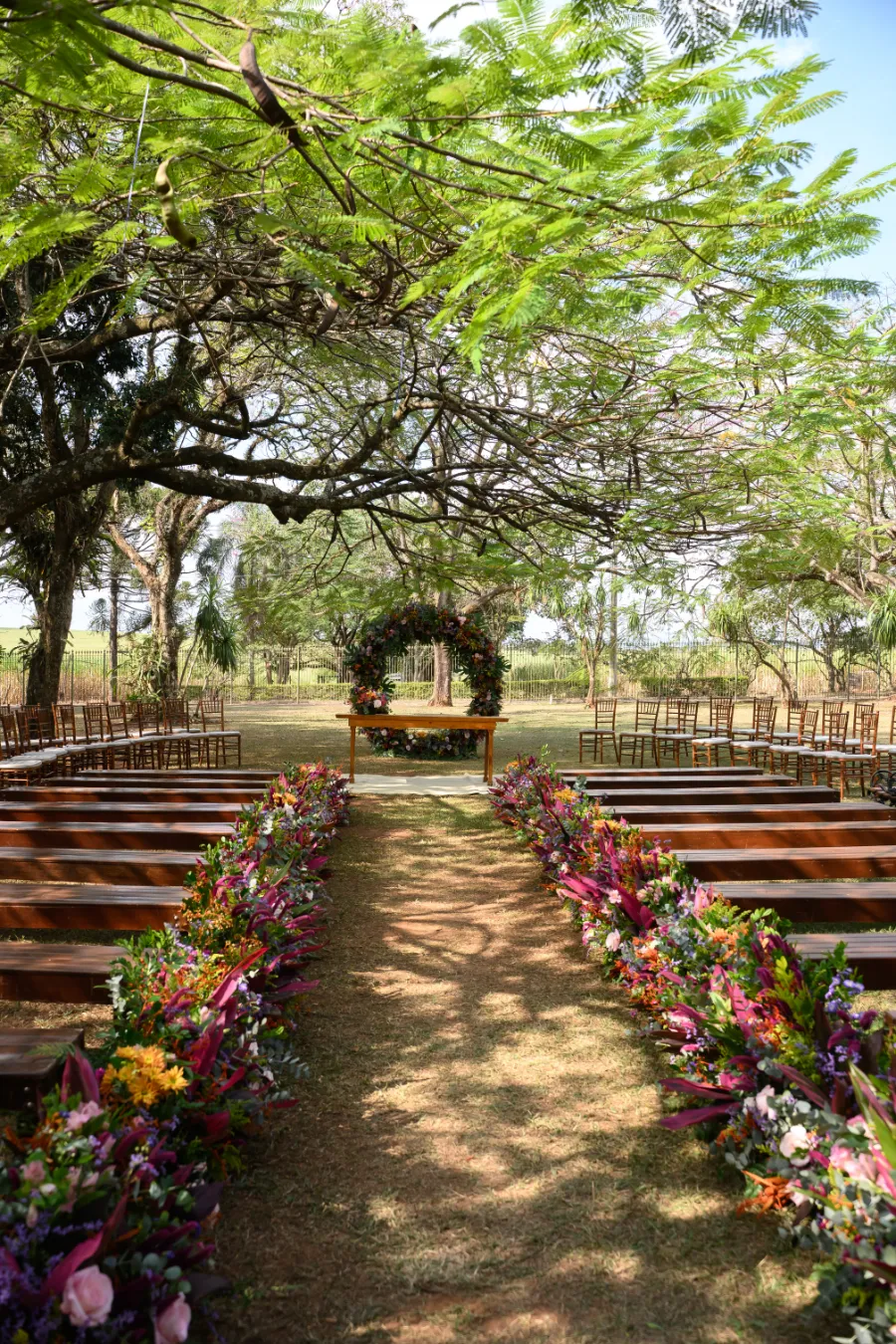 corredor decorado com flores coloridas para casamento no campo