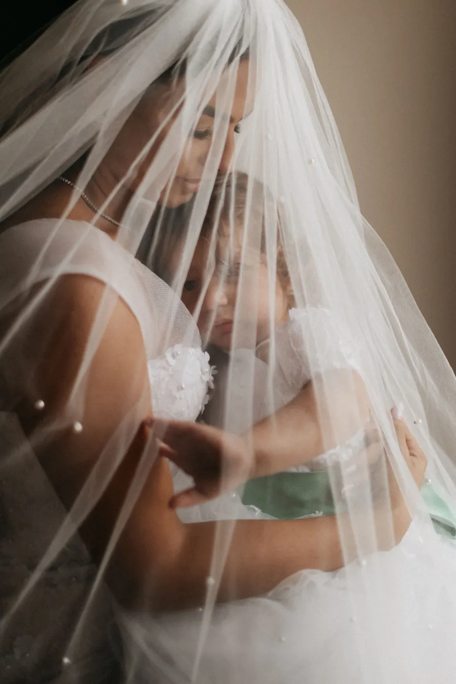 noiva com véu com bebê no colo