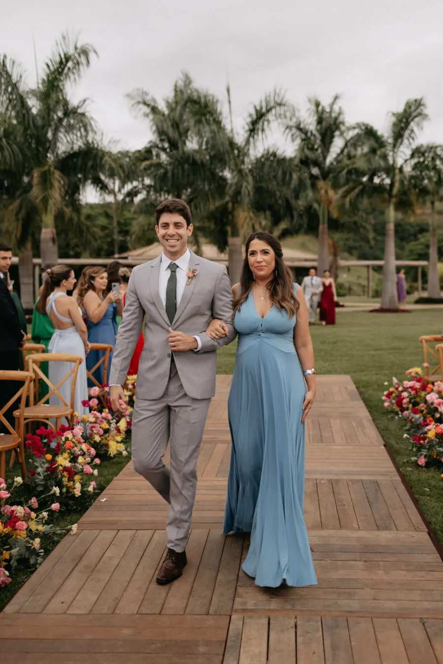 entrada da madrinha de vestido azul serenity e padrinho de terno cinza
