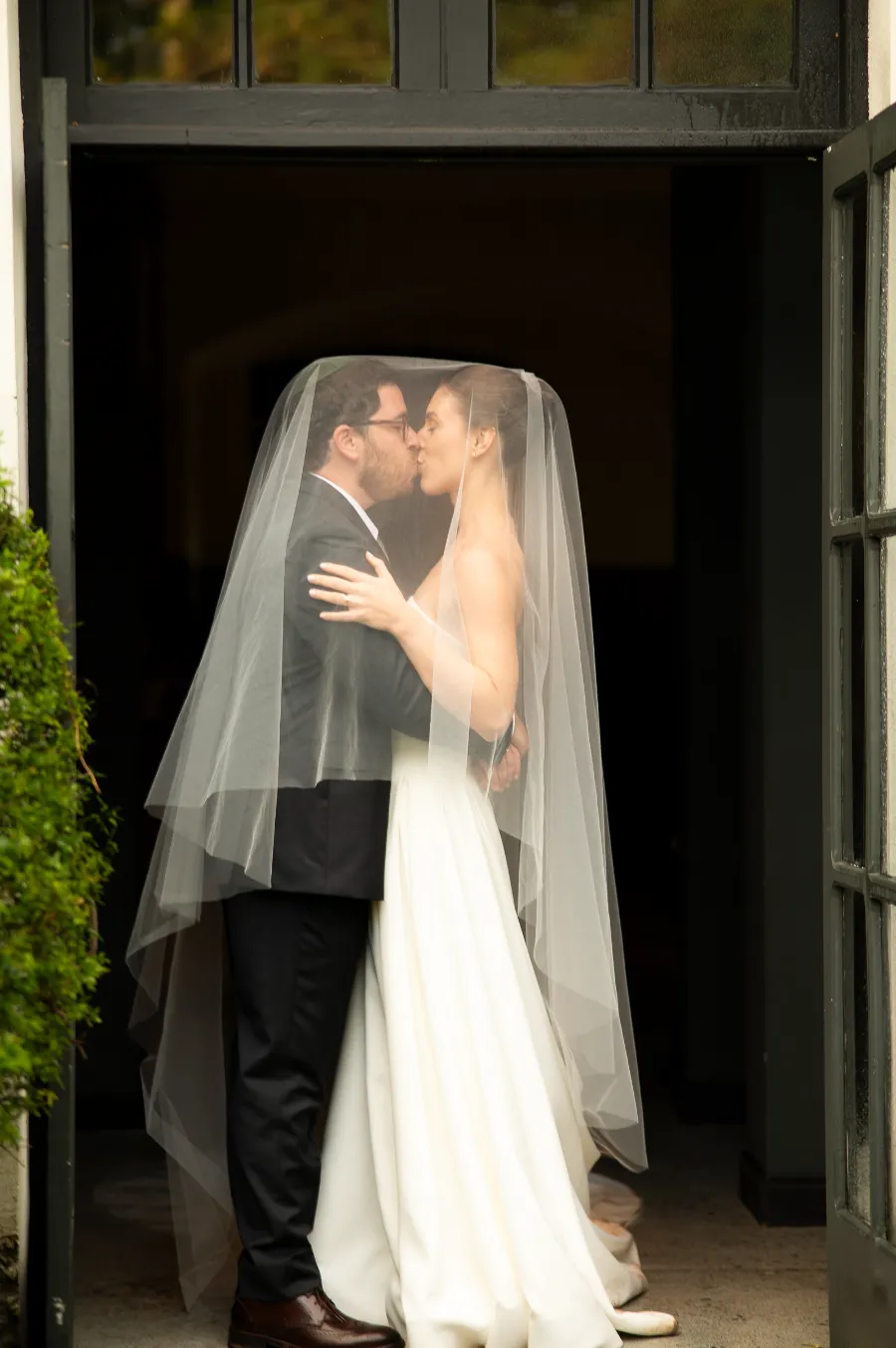 noivos se beijando sob véu