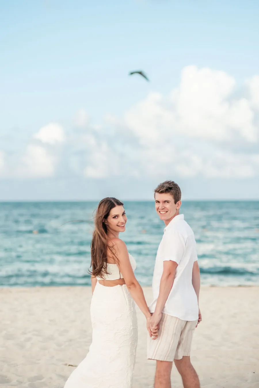noivos de mãos dadas na praia