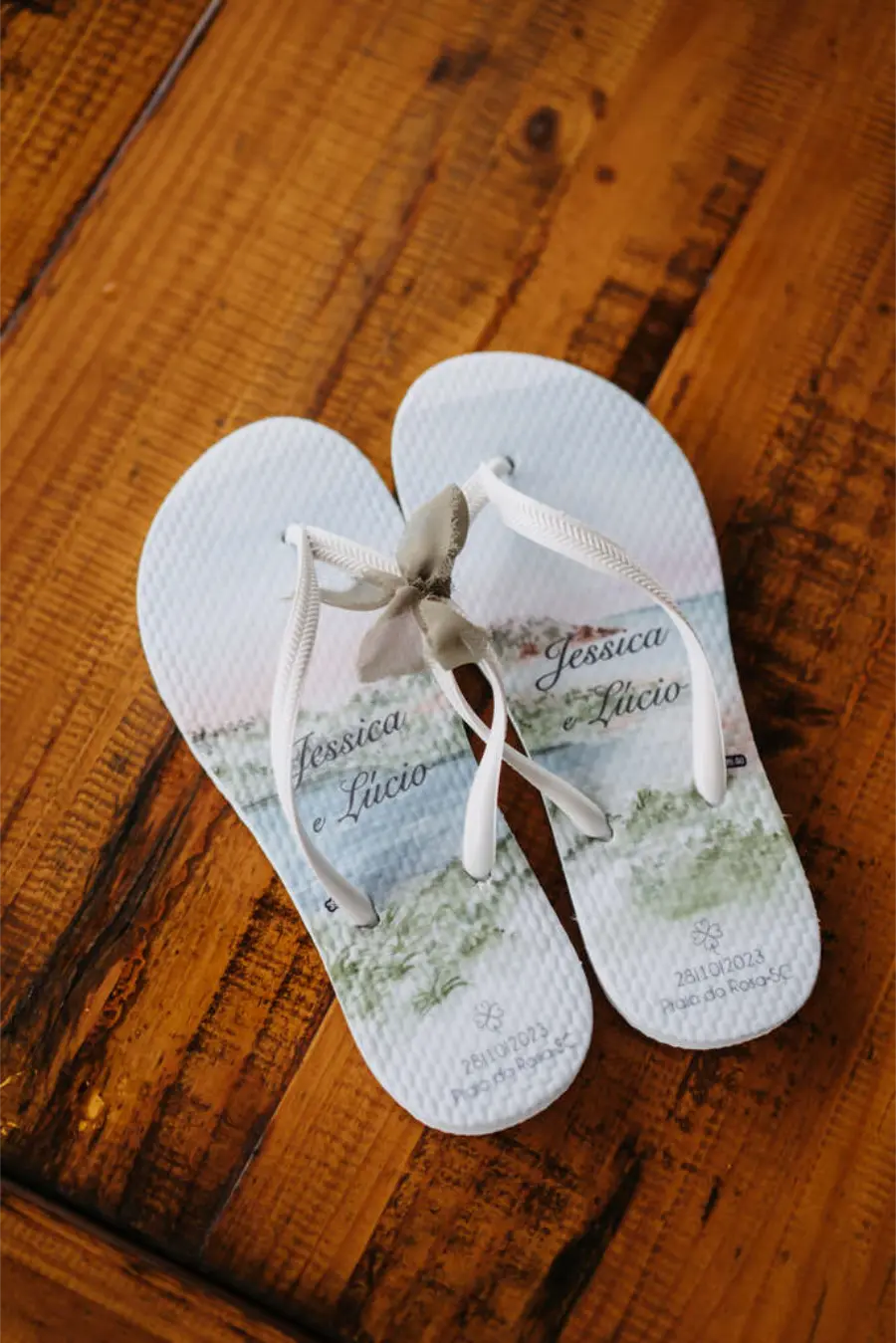 Chinelos personalizados brancos com tiras finas e estampa em aquarela dos noivos Jéssica e Lúcio com data do casamento.