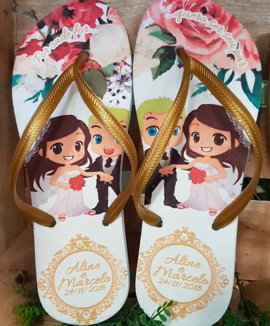 Chinelos personalizados com tiras douradas, ilustração de noivos em estilo cartoon, nomes Aline e Marcelo e data.