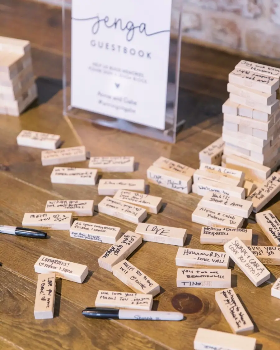 Blocos de Jenga usados como livro de assinatura alternativo em casamento, com mensagens escritas pelos convidados.