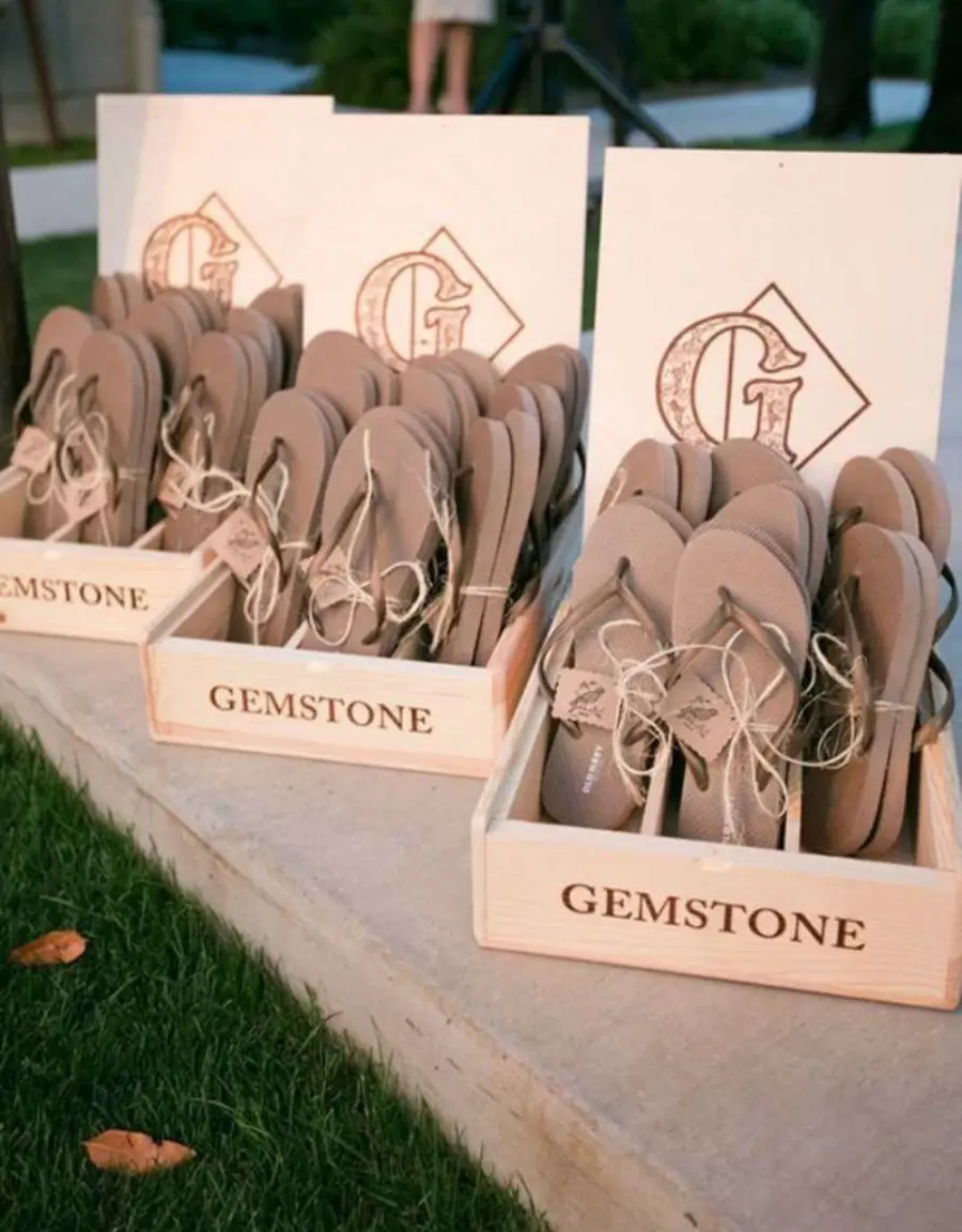 Caixas de madeira com chinelos personalizados em tom neutro para lembrancinha de casamento elegante.