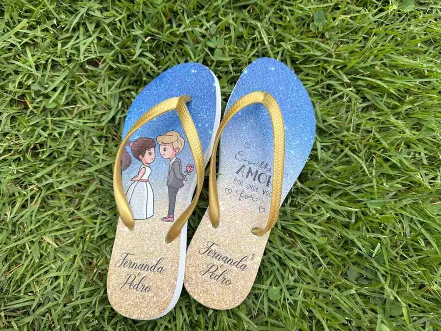 Chinelos personalizados com tiras douradas, ilustração de noivos em aquarela e nomes Fernanda e Pedro.