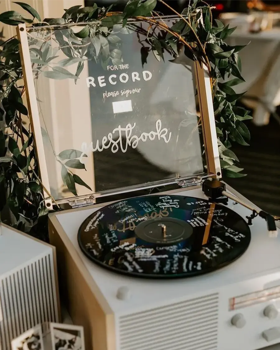 Toca-discos com disco de vinil personalizado, usado para receber assinaturas e mensagens dos convidados.