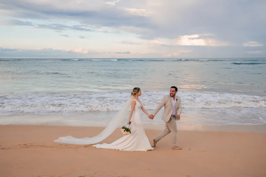 casal andando de mãos dadas na praia