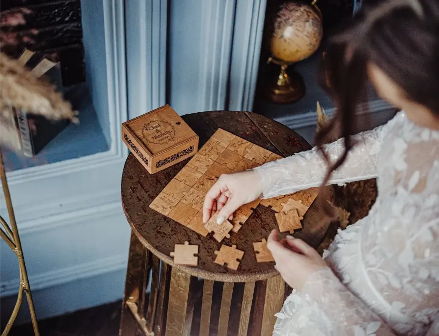 Noiva montando quebra-cabeça de madeira personalizado como alternativa ao livro de assinaturas.