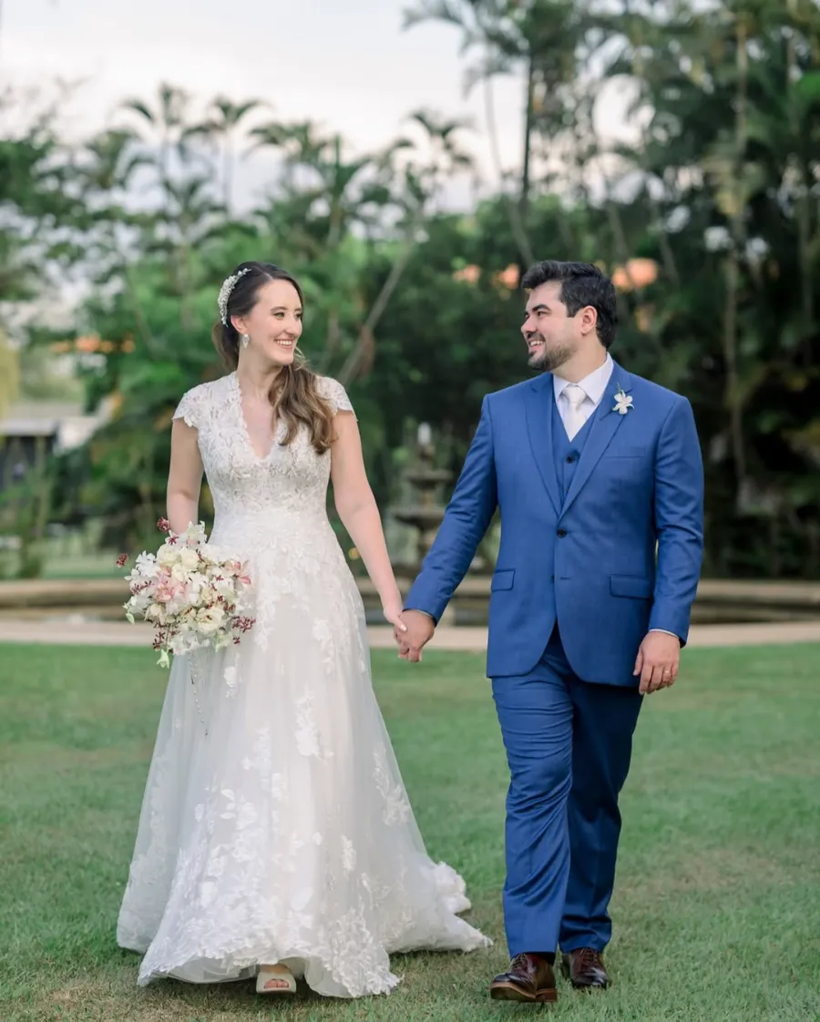 noivos caminhando de mãos dadas no casamento elegante ao ar livre