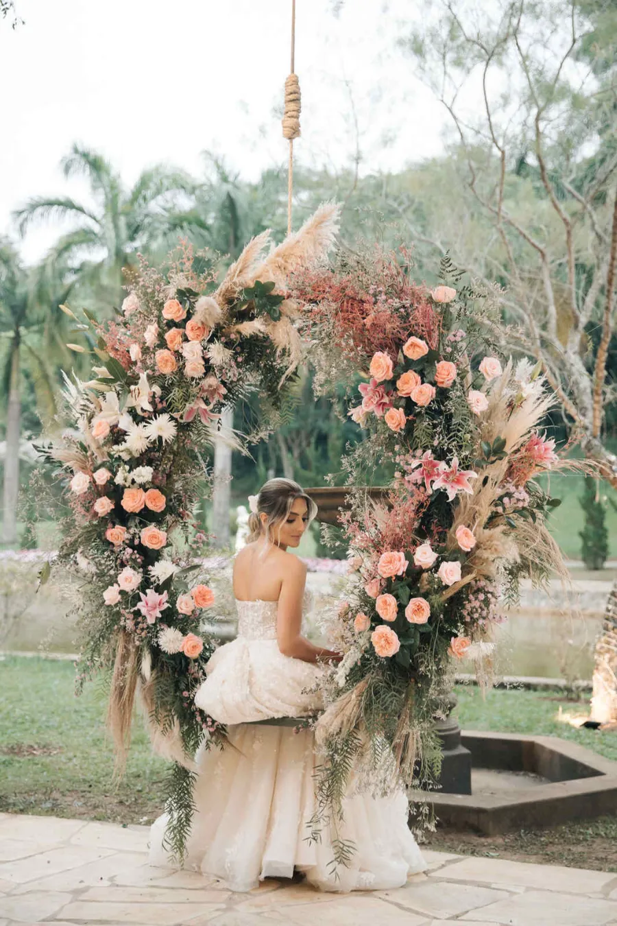 noiva sentada em balanço decorado com flores