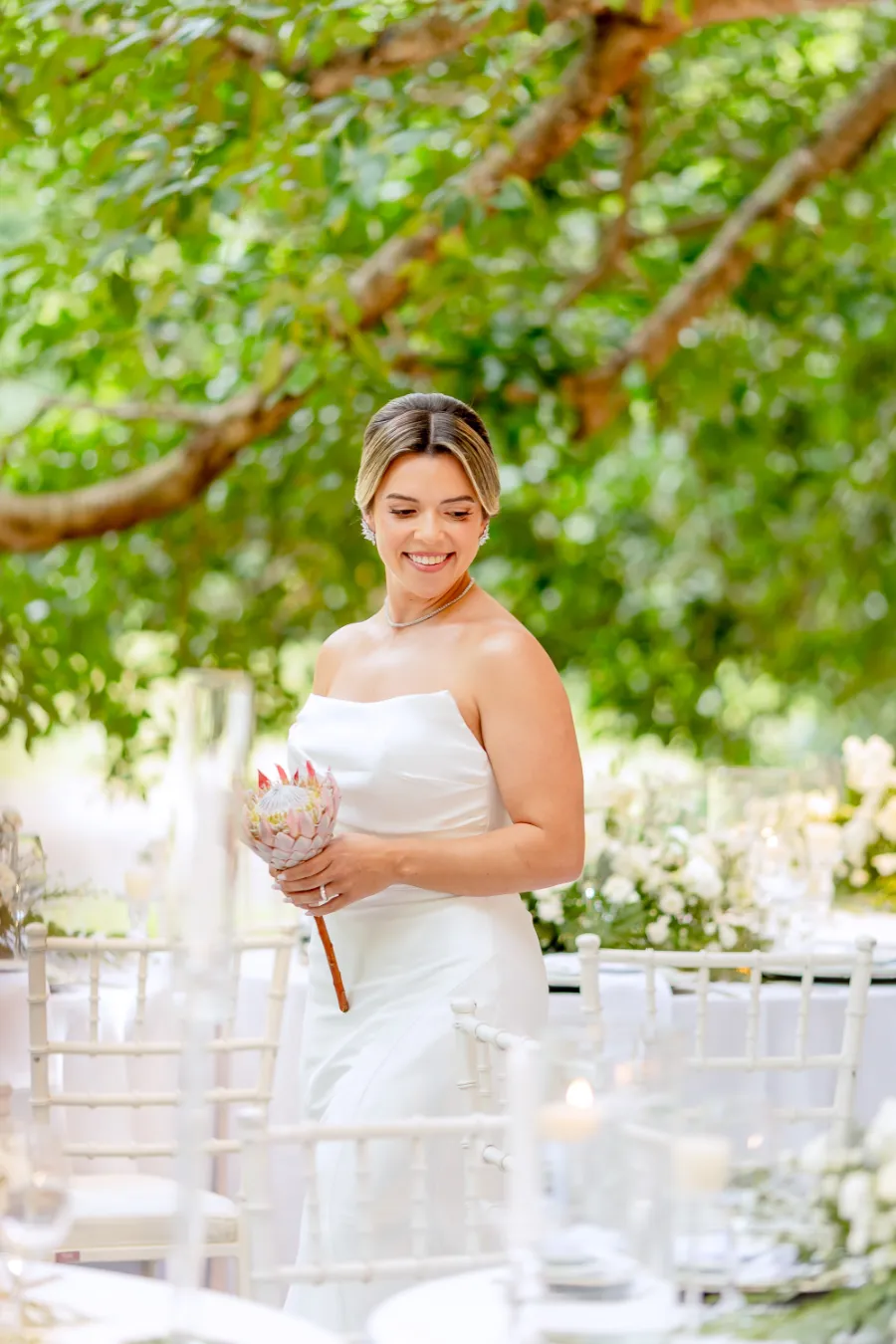 noiva sorrindo segurando buque com protea