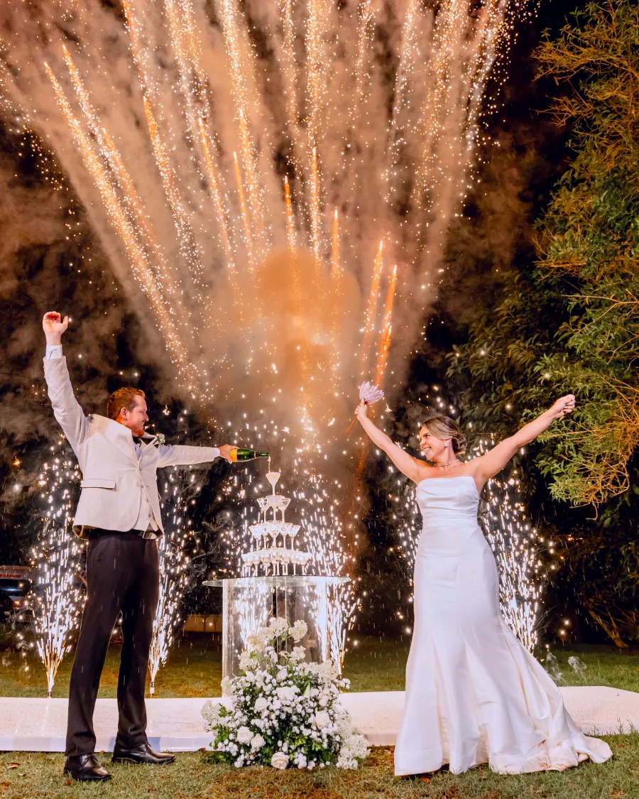 noivos brindando e fogos de artificio ao fundo