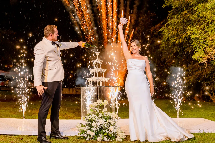 noivos brindando e fogos de artificio ao fundo