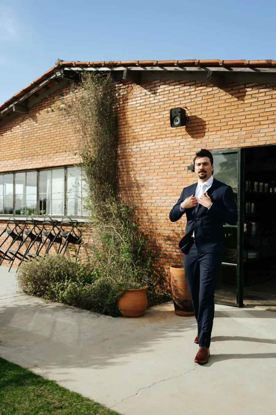 noivo na frente de casa de tijolos