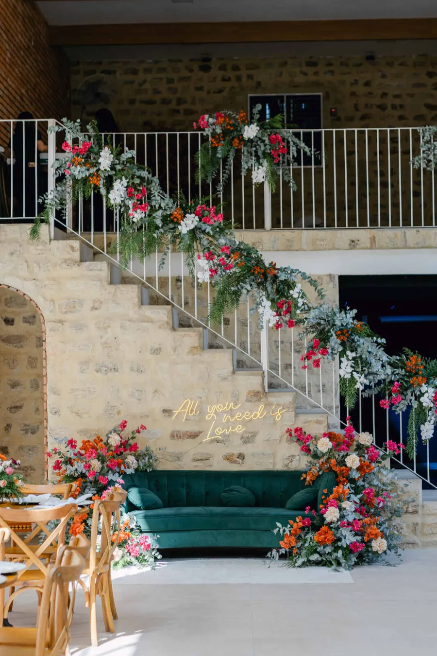 lounge decorado com flores e sofá verde petroleo