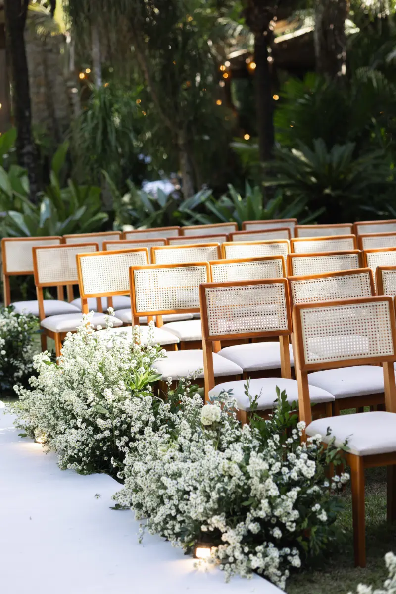 espaço da cerimônia com cadeiras brancas e arranjos de flores brancas