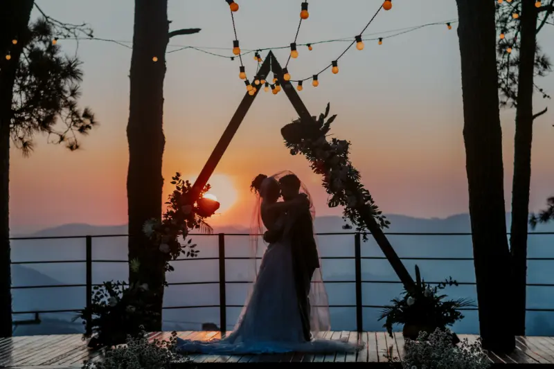 noivos abraçados em altar triangular ao por do sol