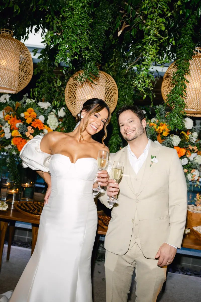 noivos brindando em frente a mesa do bolo