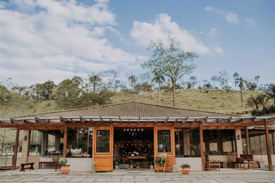 Fazenda para casamento com arquitetura colonial, varanda coberta e paisagem rural montanhosa