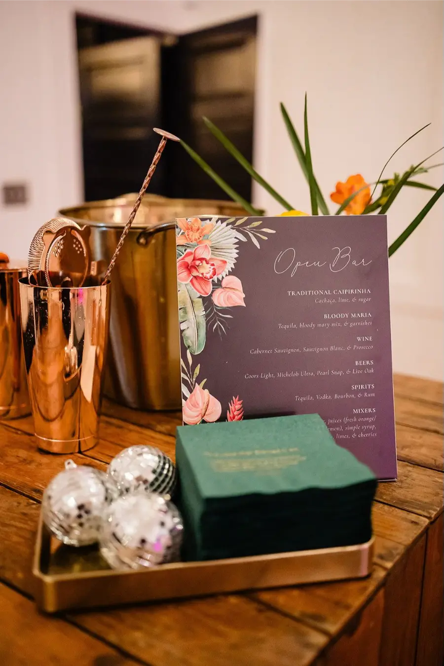 Cardápio de open bar de casamento em fundo roxo com ilustrações florais tropicais e detalhes dourados.
