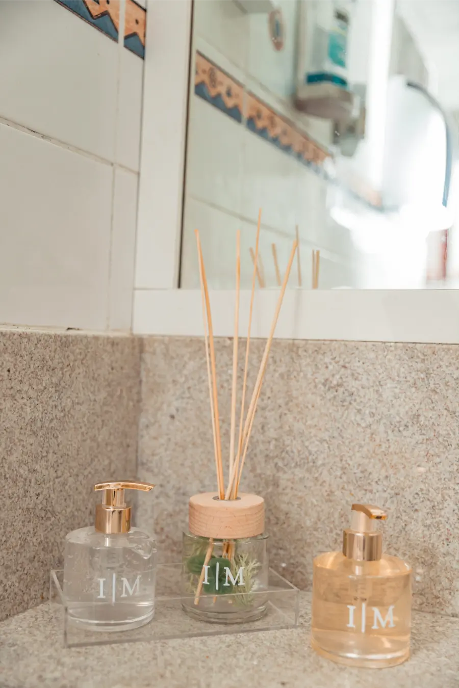 Kit toilette de casamento com sabonete líquido e difusor personalizados com as iniciais I e M.