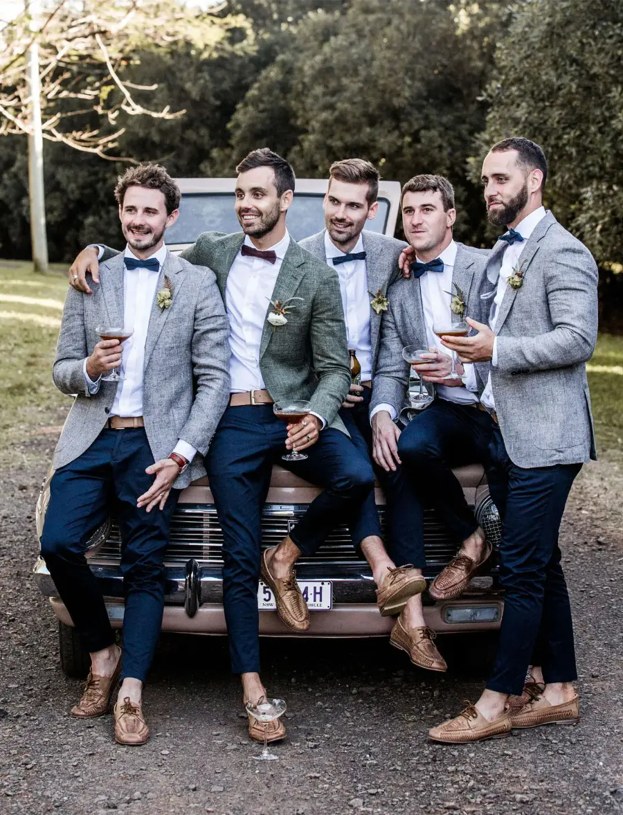 Padrinhos de casamento com gravata borboleta colorida, blazer cinza claro