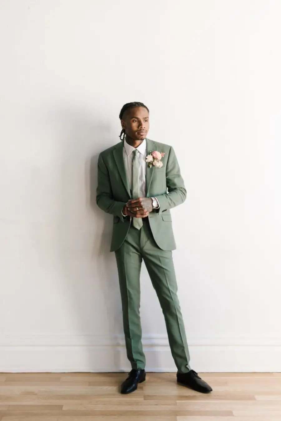 Noivo ou padrinho de terno verde com gravata clara estampada e boutonni&egrave;re de rosa, estilo elegante e minimalista