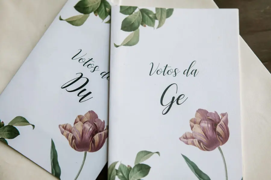 Votos de casamento personalizados com design floral delicado, decorados com tulipas rosa e folhagens verdes