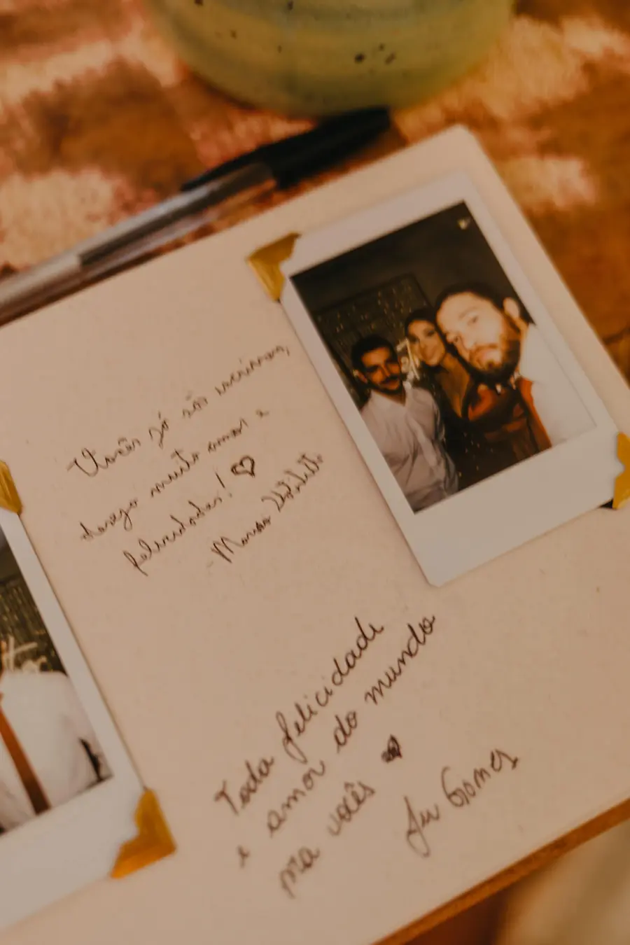 Página de livro de convidados com foto instantânea colada e mensagens escritas à mão, registrando votos de felicidade aos noivos.