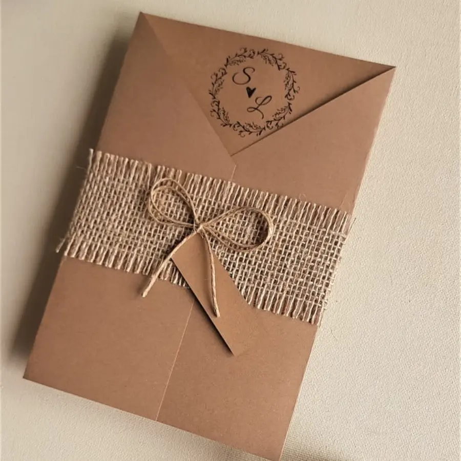 Convite de casamento simples em papel kraft com faixa de juta e laço de barbante, estilo rústico.