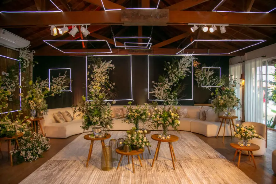 Lounge para casamento com decora&ccedil;&atilde;o moderna, sof&aacute;s bege e instala&ccedil;&atilde;o de folhagens suspensas