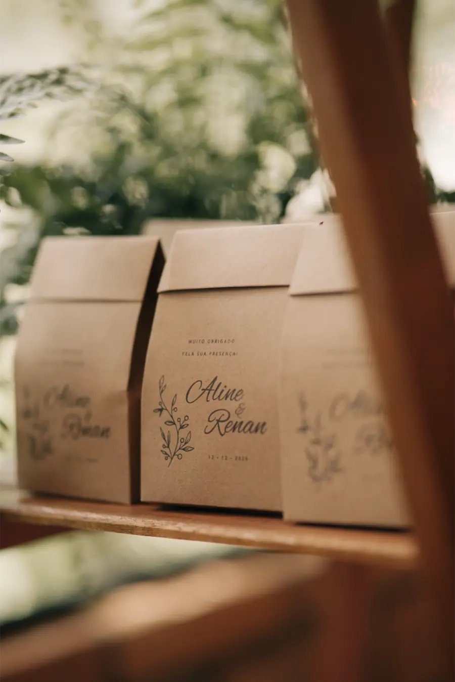 Sacolinhas de papel kraft personalizadas com nomes dos noivos "Aline & Renan", usadas como lembrancinhas sustentáveis de casamento.