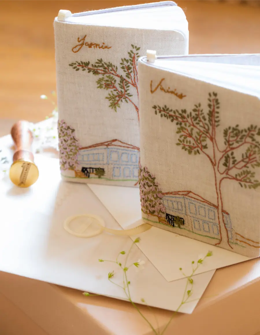 Livros de votos bordados à mão com ilustração de cenário e nomes dos noivos Yasmim e Vinicius.