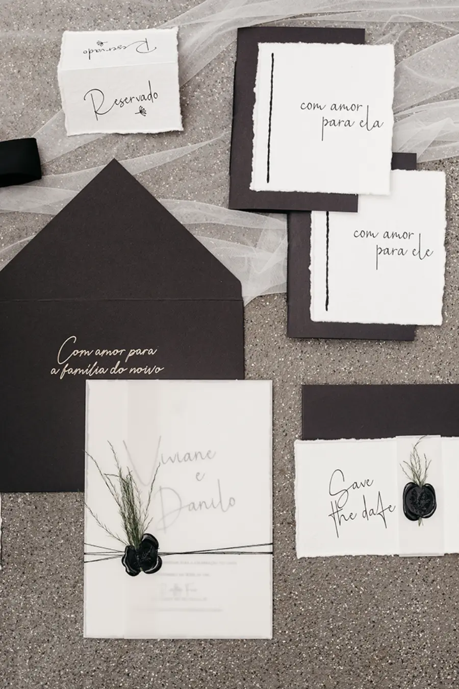 Papelaria de casamento em preto e branco com envelopes, save the date e convites, decorados com lacre de cera preta e ramos secos.