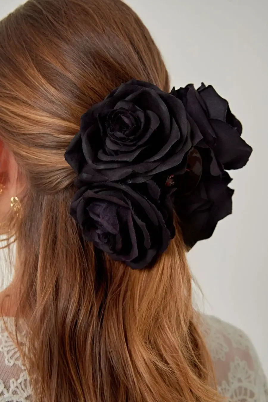 Cabelo preso com presilha de rosas pretas artificiais como acess&oacute;rio de noiva.