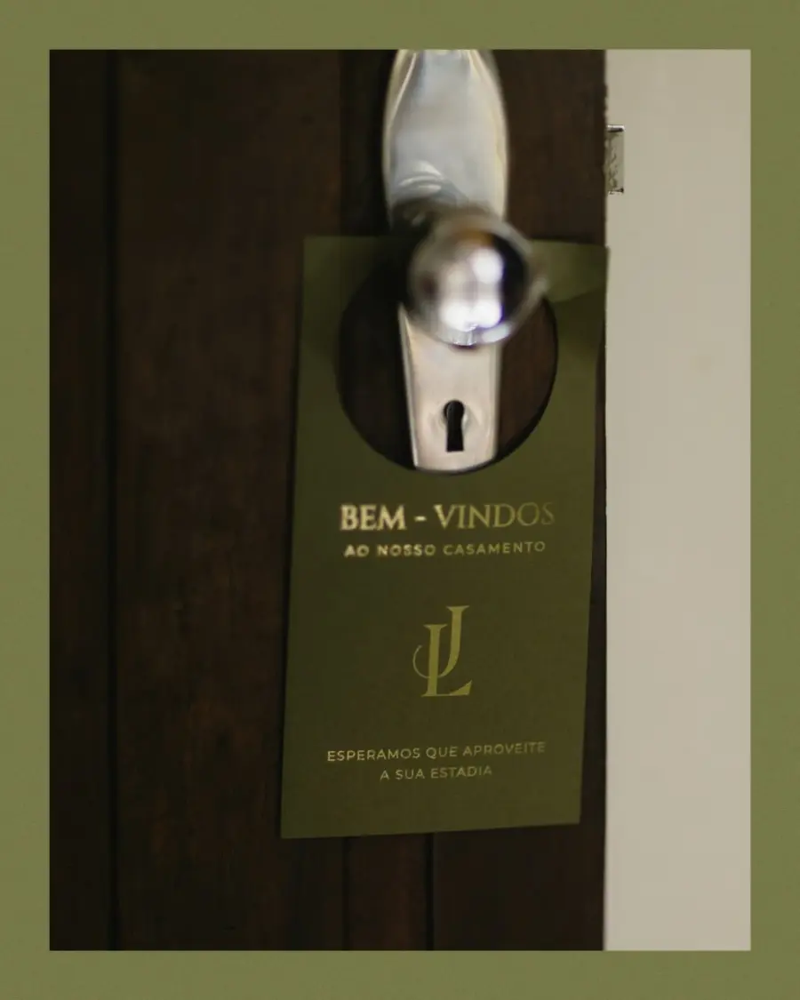 Tag de boas-vindas de casamento em verde musgo com iniciais JL, pendurada na maçaneta da porta para recepção de convidados.