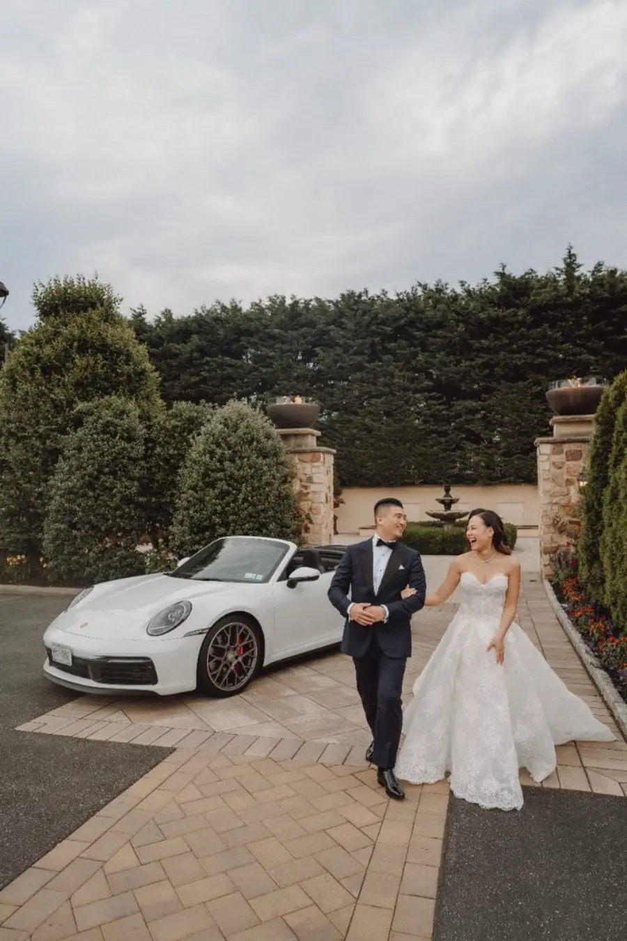 Noivos ao lado de carro para casamento esportivo