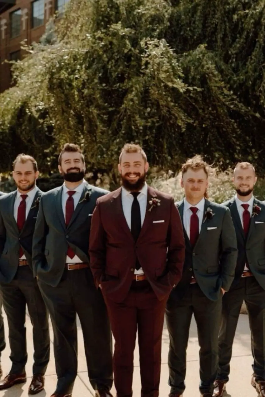 Noivo de terno bord&ocirc; e padrinhos de terno cinza com gravata vermelha