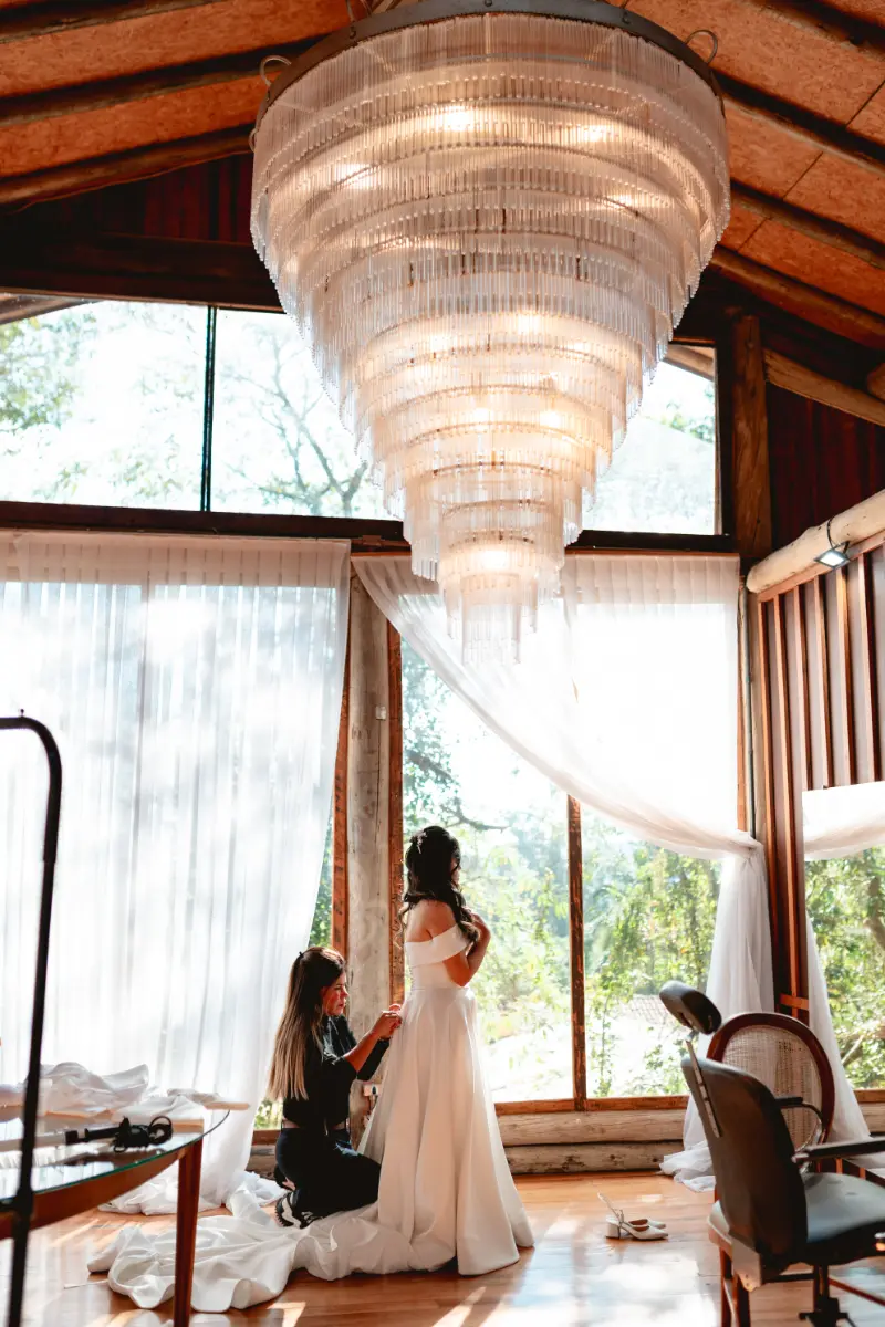 noiva tendo ajuda para arrumar o vestido