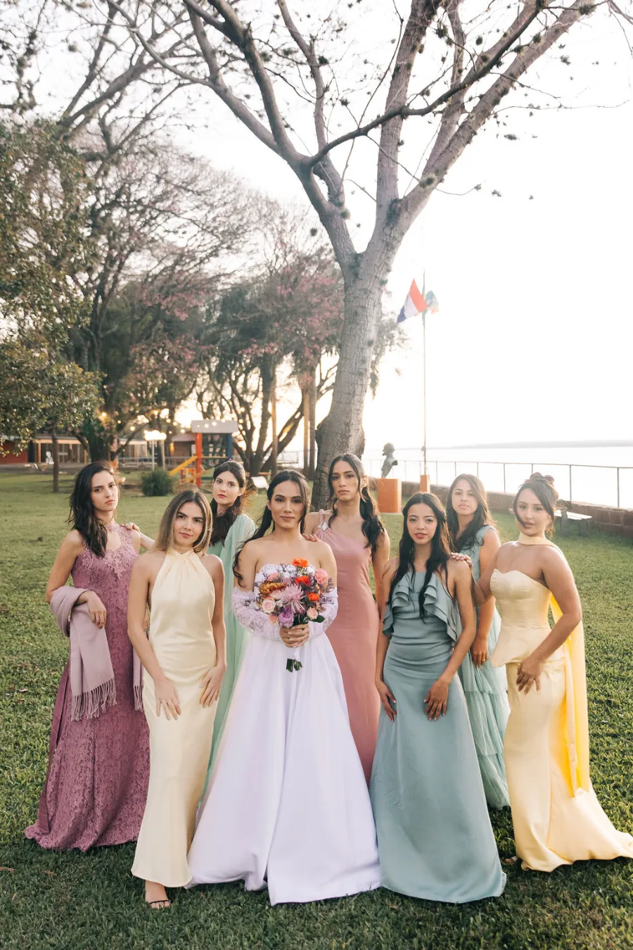 noiva ao lado de madrinhas com vetsidos em cores pasteis