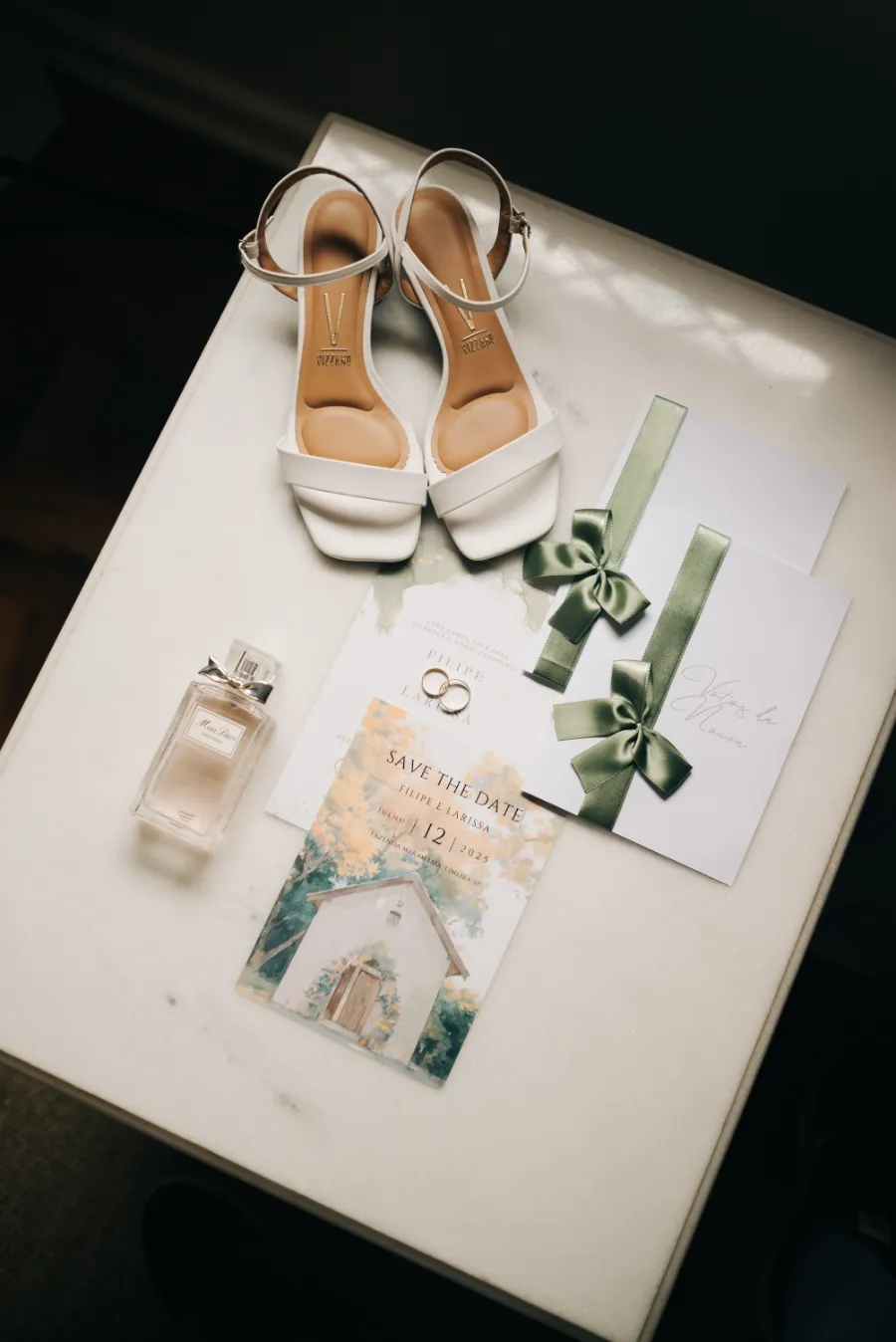 sandalia da noiva ao lado de papelaria de casamento e perfume