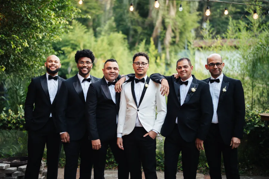 noivos de smoking branco ao lado dos padrinhos