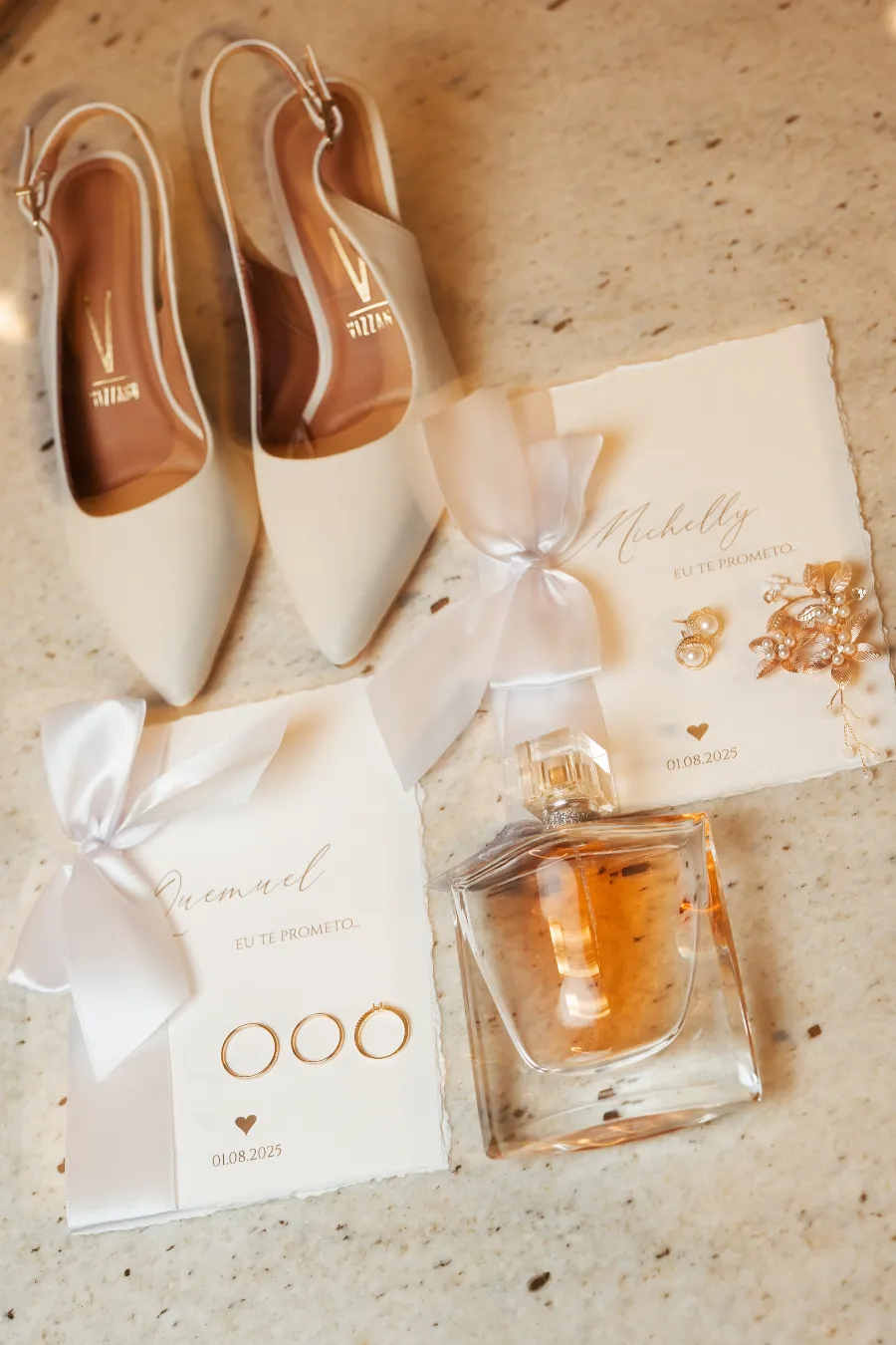 sandalia de noiva ao lado de caderno de votos e perfume