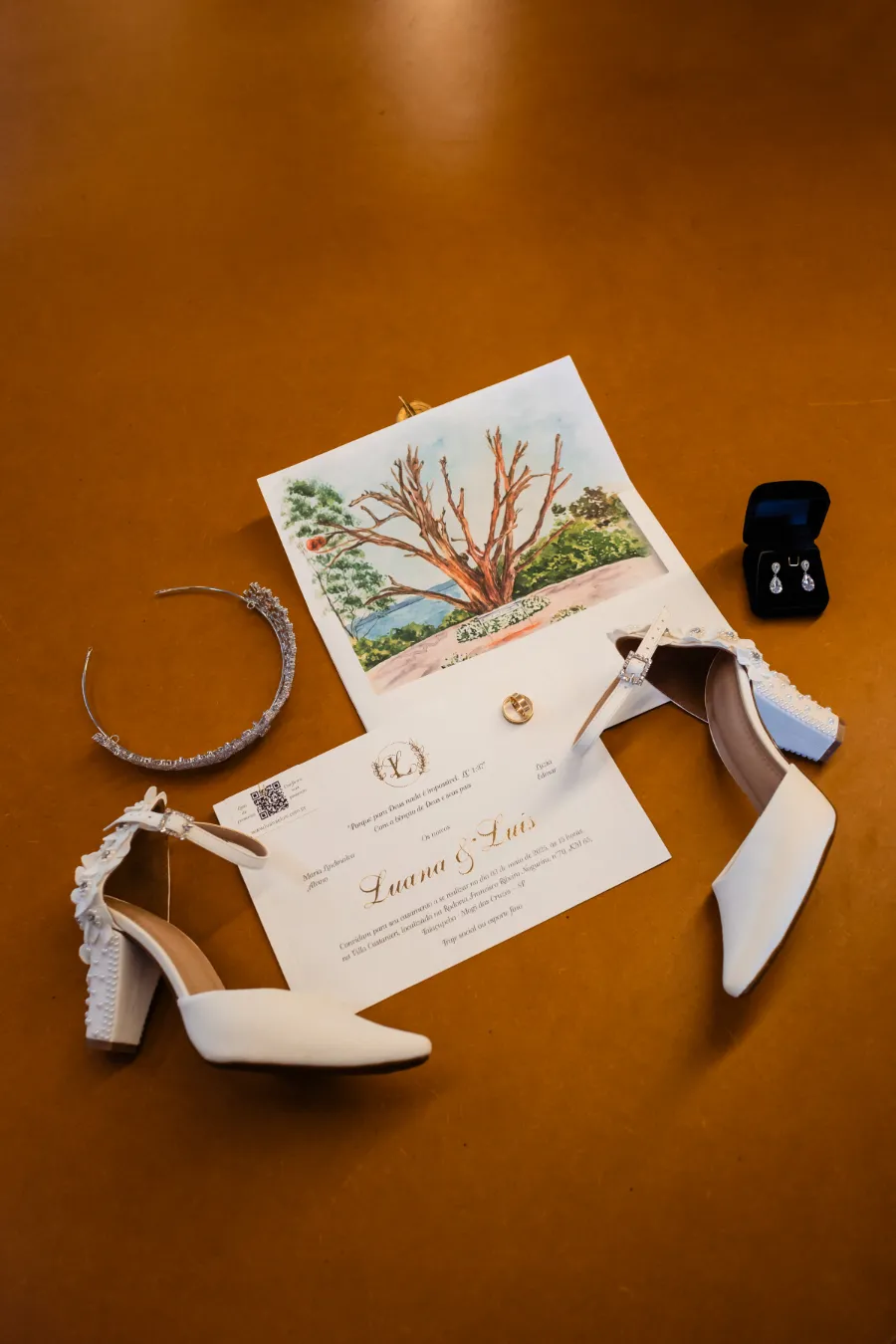 convite de casamento ao lado de brincos, sapatos e tiara